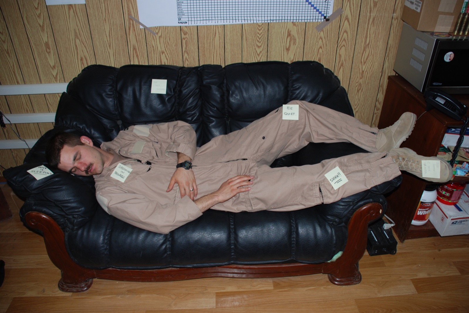 Two deployed aircrew resting together on a sofa